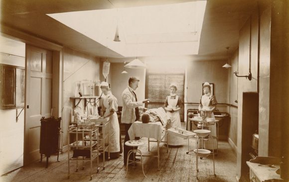 Doctor anaesthetising patient, nurses in attendance