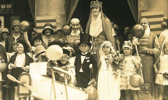 children and adults dressed up in costumes holding balloons