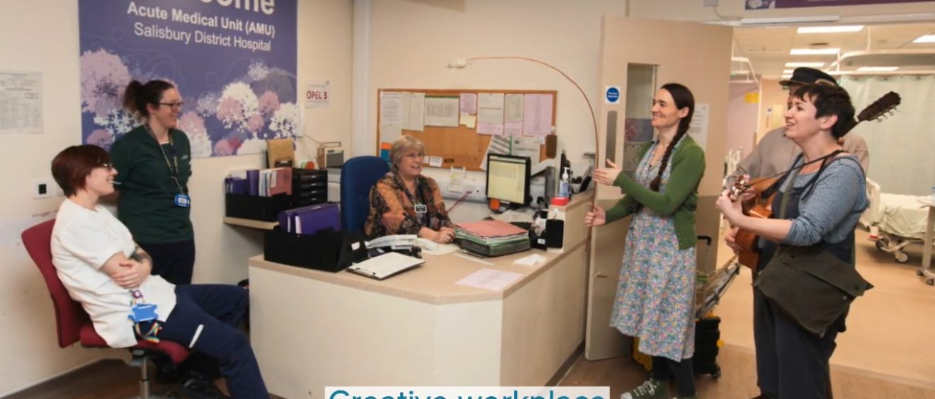 performers with albatross puppet and instruments interact with staff on ward reception
