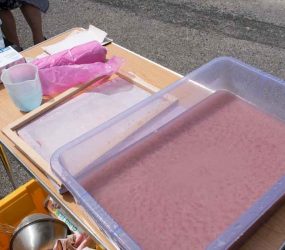 plastic container, jug, apron, frame and deckle on table