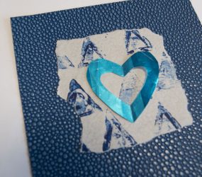 blue cut out heart layered onto blue monoprint