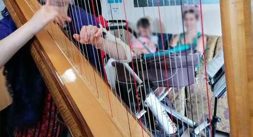 Emmy playing harp to parents and babies