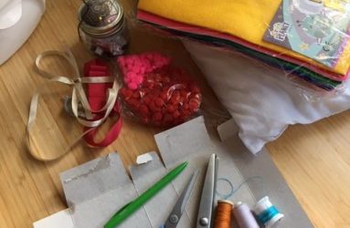 materials and equipment laid out including scissors, thread, felt and ribbon