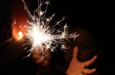 hands holding a sparkler in the dark
