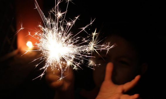 hands holding a sparkler in the dark
