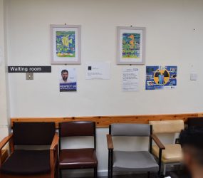 Mismatched chairs, old signs and posters on the wall