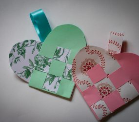 two finished wove hearts with ribbon attached to hang