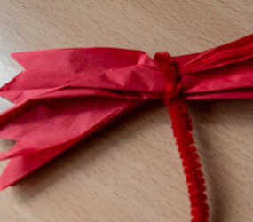 pipe cleaner tied around the middle of folded tissue paper
