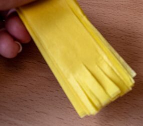 cutting slits into end of folded tissue paper