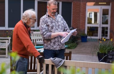 Volunteer looking at plans for garden with ArtCare technician