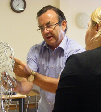 Martin working on wire figure with staff member