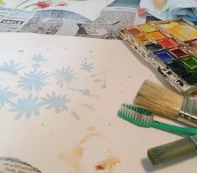 brushes, toothbrush, palette, paper and daisy outline in masking fluid